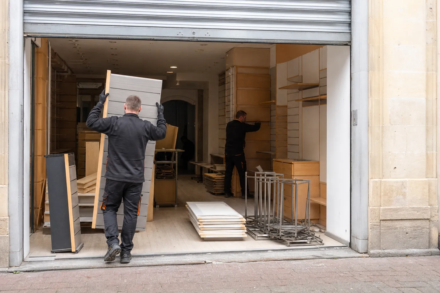 Magasin fermé en cours de vidage, étagères démontées